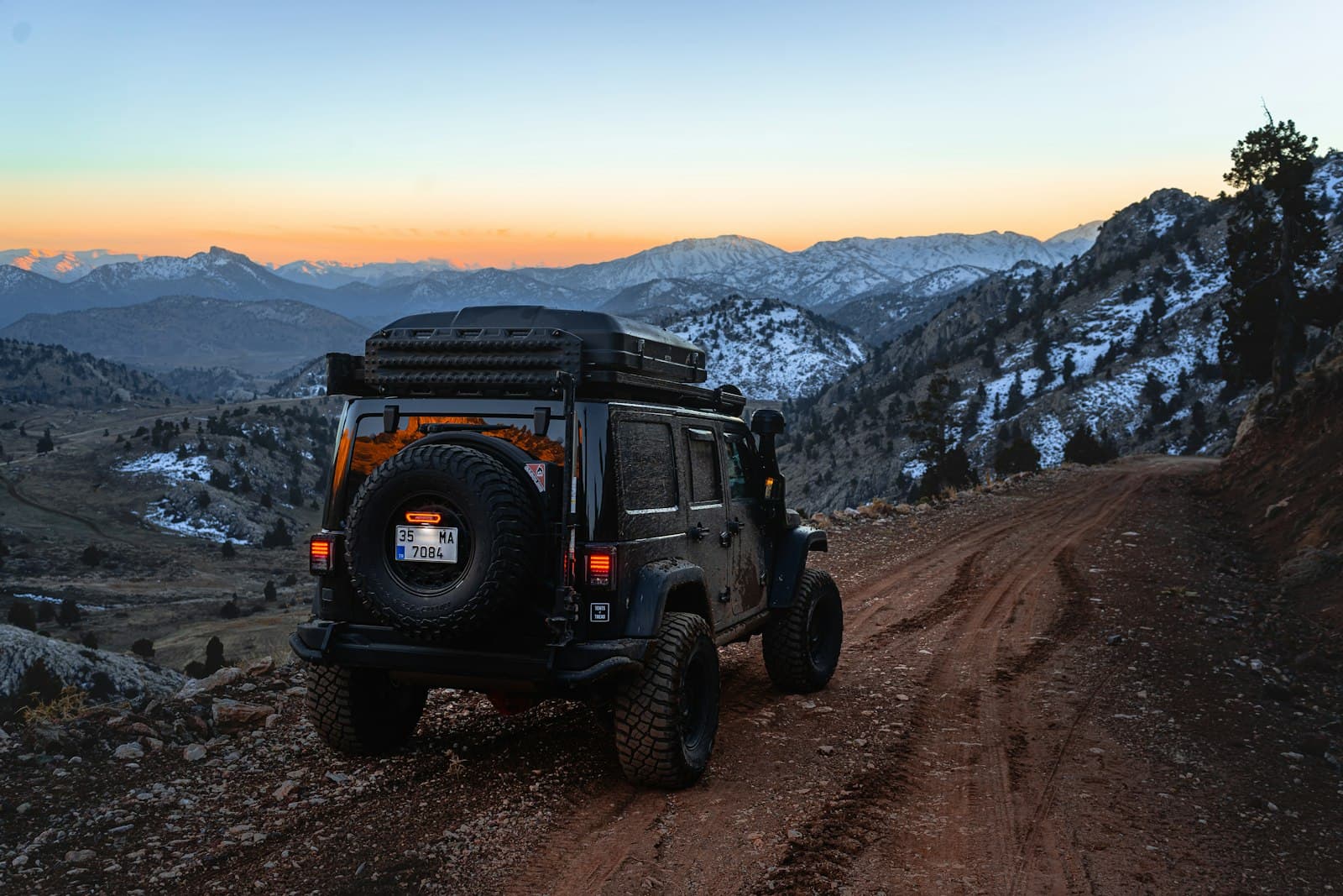 4x4 tout-terrain équipé sur une piste de montagne au crépuscule